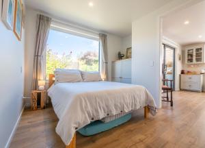 a bedroom with a bed and a large window at Studio at Pohara in Pohara +2 photos