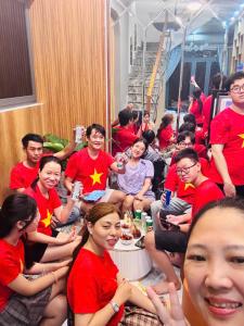 a group of people in red shirts sitting at Ruby Home Quy Nhon in Quy Nhon