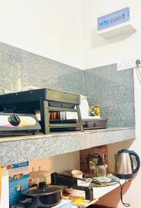 a stove top oven sitting on top of a shelf at Windy Oasis in Hikkaduwa
