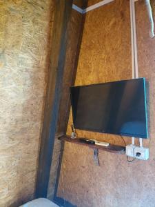 a flat screen tv sitting on a wall at Cozy Lakefront Cabin - Myselim in Shkodër