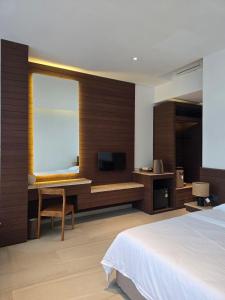 a bedroom with a bed and a desk and a television at Sabi by the Sea Kep in Kep