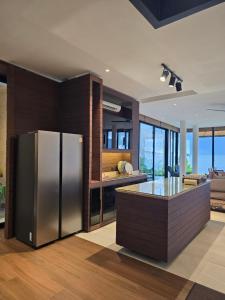 a kitchen with a stainless steel refrigerator and a table at Sabi by the Sea Kep in Kep