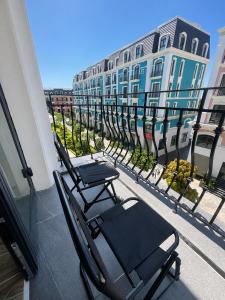 a couple of chairs on a balcony with buildings at K-Dragon Hotel Đồi Rồng, Đồ Sơn in Ðông Thôn