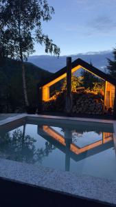 a house with a reflection in a pool at Cabana207 - Private Mountain Cabin with Hot Tub in Bulz
