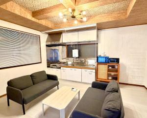 a living room with a couch and a table at Harbor Terrace Izu OceanView in Ito