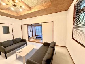 a living room with a couch and a table at Harbor Terrace Izu OceanView in Ito