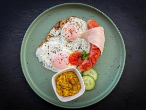 a plate of breakfast food with eggs and tomatoes at Seven Minutes Ella by SANS in Ella