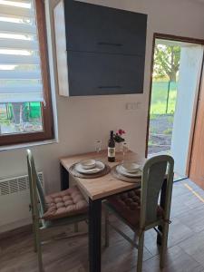 a dining room table with two chairs and a table and a window at Ubytování na ranči in Hrabětice