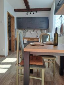 a kitchen with a table with chairs and a dining room at Ubytování na ranči in Hrabětice