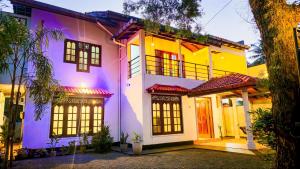 a house with a purple and yellow facade at Surf and stay in Weligama