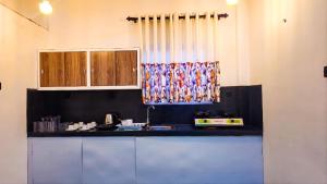 a kitchen with a black counter top and a window at Surf and stay in Weligama