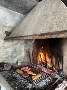 a grill with a bunch of hamburgers and food on it at Villa Linda in Schio
