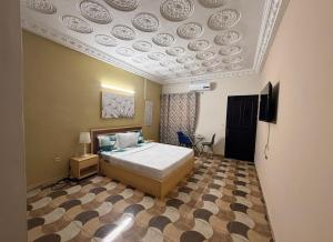 ein Schlafzimmer mit einem Bett, an dessen Decke Teller hängen in der Unterkunft Bethany Hotel in Abidjan + 13 Fotos