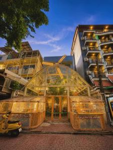 a glass building with a scooter parked in front of it at Lazy Sunday Khaosan Hotel in Bangkok