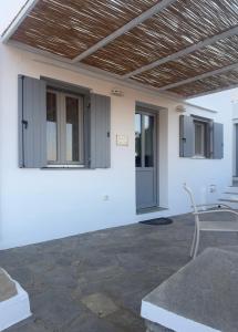 a white house with a wooden roof and a patio at Kety’s house in Exámbela