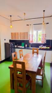 a kitchen with a wooden dining table and chairs at Surf and stay in Weligama
