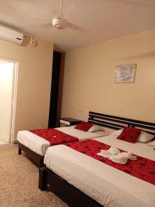 a hotel room with two beds with red pillows at Hotel Resident Piura in Piura