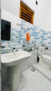a bathroom with a sink and a toilet at Azura Hotel in Pottuvil