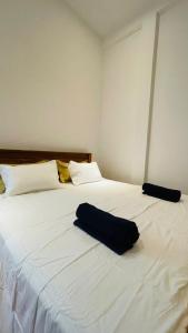 a large white bed with a black pillow on it at Azura Hotel in Pottuvil +5 photos