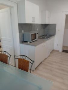 a kitchen with a microwave and a counter with two chairs at Petit studio in La Souterraine