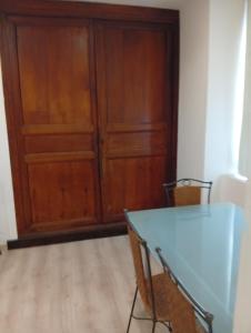 a wooden cabinet in a room with a table at Petit studio in La Souterraine