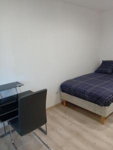 a bedroom with a bed and a desk next to a bed sidx sidx at Petit studio in La Souterraine
