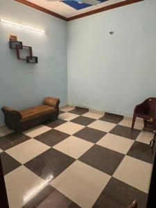a waiting room with a couch and a checkerboard floor at Dixit's Villa in Kānpur