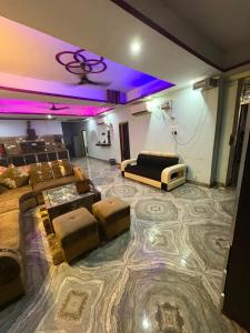 a room with a stage with a couch and a tv at Dixit's Villa in Kānpur +3 photos