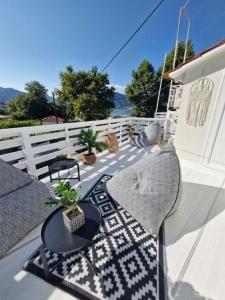 a patio with a couch and tables and a fence at Summer House Moschovi in Skala Potamias