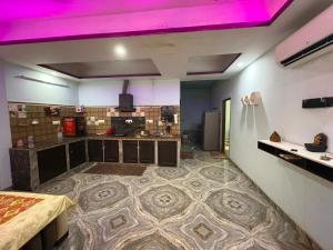 a large room with a kitchen with purple lighting at Dixit's Villa in Kānpur