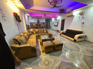 a large living room with couches and tables and purple lights at Dixit's Villa in Kānpur