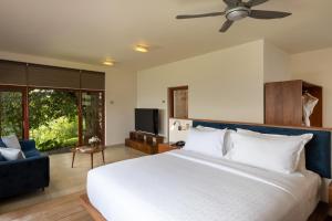 a bedroom with a large white bed and a couch at Kandy Knightsdale Villa in Panwila