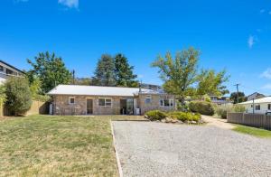 a house with a driveway in front of a yard at Rock On in Jindabyne