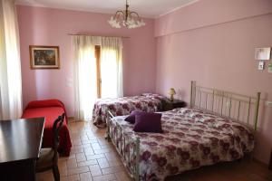 a bedroom with two beds and a table and a window at Agriturismo Camera Rosa in Todi