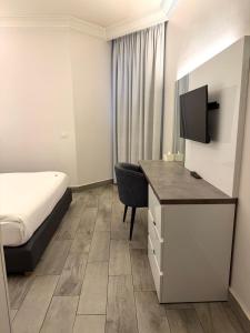 a hotel room with a bed and a desk with a television at Ny Suites in Beirut