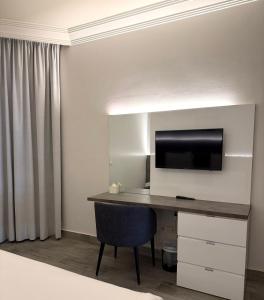 a room with a desk with a television and a chair at Ny Suites in Beirut
