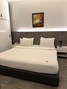 a bedroom with a large bed with a white bedspread at Ny Suites in Beirut