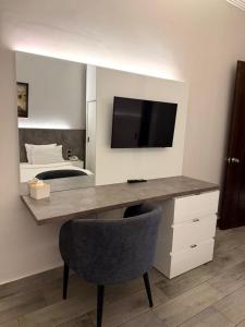 a room with a desk with a television and a bed at Ny Suites in Beirut