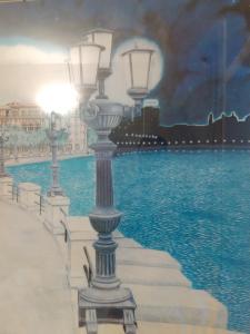 una pintura de una luz de la calle en el agua en Clear and Cheap, en Bari