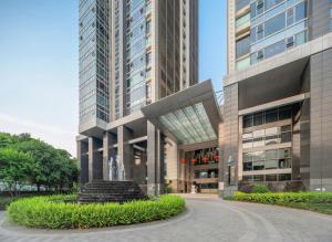 a large building with a fountain in front of it at INVIS Urban High-rise Suites in Chengdu