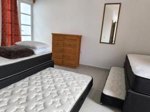 a bedroom with two beds and a dresser and a mirror at Loft los Colibries 6 parking option in Tlaxcala de Xicohténcatl