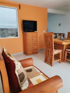 a living room with a couch and a desk and a television at Loft los Colibries 6 parking option in Tlaxcala de Xicohténcatl