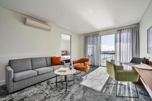 a living room with a couch and a table at Quest Port Adelaide in Adelaide