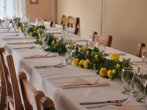 a row of tables with white table cloth and yellow flowers at Silentium Clavem Domus III. in Odorheiu Secuiesc