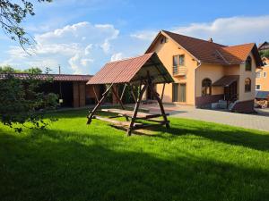 a swing in a yard in front of a house at Silentium Clavem Domus III. in Odorheiu Secuiesc