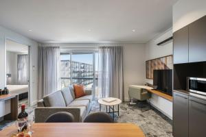 a living room with a couch and a television in a room at Quest Port Adelaide in Adelaide