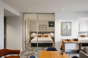 a hotel room with a bedroom and a bed at Quest Port Adelaide in Adelaide +48 photos
