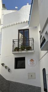 a white building with a balcony and a window at B&B SEnDA de alegria in Cómpeta
