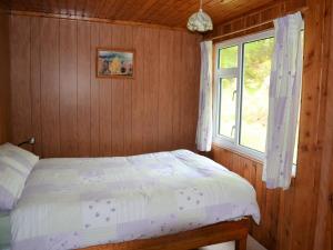 a bedroom with a bed and a window at Faichemard Farm Chalets in Invergarry