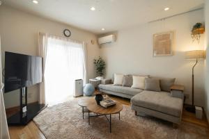 a living room with a couch and a table at Nagano Villa 翠 in Nagano